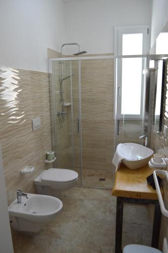 a bathroom with a shower and a toilet and a sink at Residenza Case Arse in Torre Lapillo