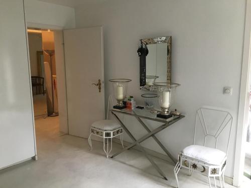 a room with a table and two chairs and a mirror at Einfamilienhaus im Landhausstil in Meerbusch