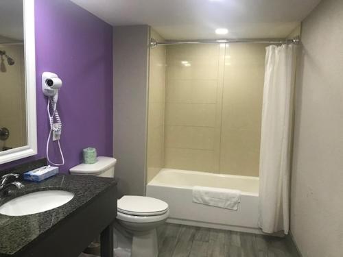 a bathroom with a toilet and a sink and a bath tub at Alamar Resort Inn in Virginia Beach