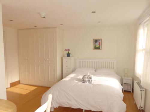 a bedroom with a white bed in a room at Bright, spacious 2 bedroom flat by Russell Square in London