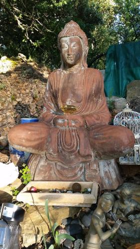 una estatua de un Buda sentado en un banco en Villa Mylena, en Jouques