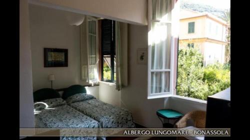 a bedroom with two beds and a window at Albergo Lungomare in Bonassola