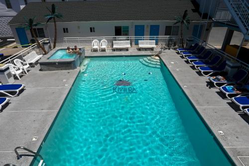 a large swimming pool with chairs and people in it at Riviera Resort & Suites in Wildwood