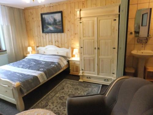 - une chambre avec un lit et un lavabo dans l'établissement Willa Katarzynka, à Wisła