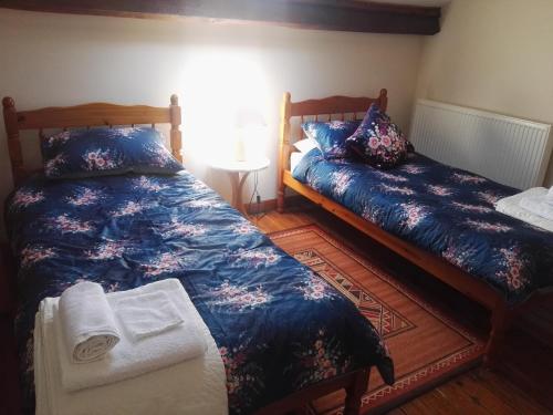 a bedroom with two beds and a table with a window at Le Chene Vert in Millac
