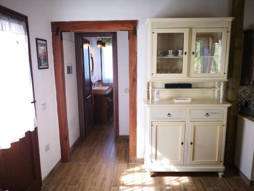 une cuisine avec une armoire blanche et un couloir dans l'établissement Villa Sa Pruna, à Oliena