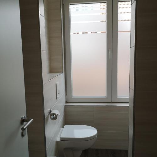 a bathroom with a toilet and a window at Haus Worch in Juist