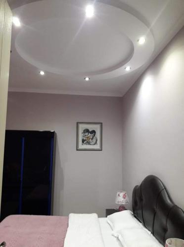 a bedroom with a bed and a ceiling at Tskaltubo Apartment Mirian Mepe in Tskaltubo