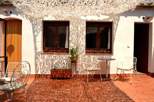 a patio with chairs and a table and windows at Marakasa B&B in Sant Antoni de Calonge