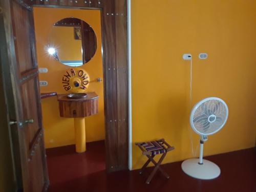 a room with a mirror and a fan in a room at Buena Onda Backpackers in San Juan del Sur