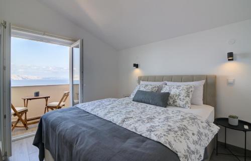 a bedroom with a bed and a view of the ocean at VisumApartments in Senj