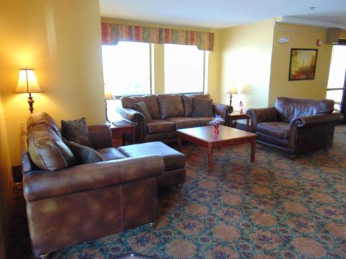 a living room with leather couches and a coffee table at Horse Creek Inn in McCook