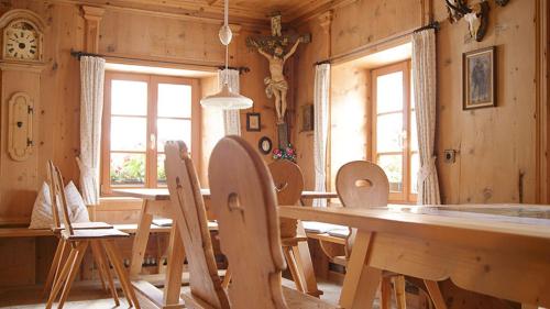 a dining room with a wooden table and chairs at Gasthof/Albergo Dasser in San Martino in Badia