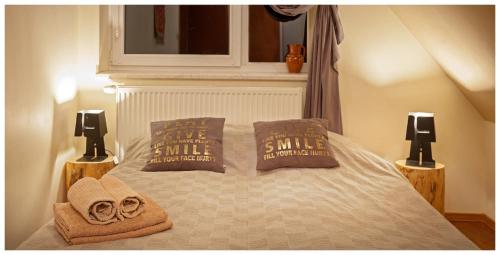 a bed with two pillows and towels on it at Tatrzańska Kotwica in Witów