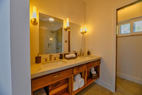 a bathroom with a sink and a large mirror at Villa Topaz Above West Bay with 360 Degree Views! in West Bay