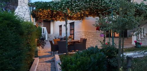 a patio with a table and chairs in a yard at Apartments Maletic in Pula