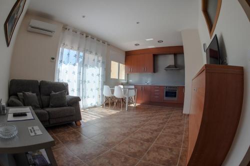 a living room with a couch and a kitchen at Apartament Can Jaumató in Sant Quirze de Besora