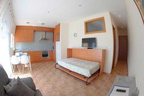 Habitación pequeña con cama y cocina en Apartament Can Jaumató, en Sant Quirze de Besora