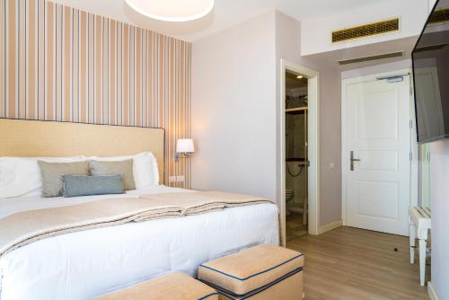 a bedroom with a large bed and a tv at Hotel Plaza in Porto Azzurro