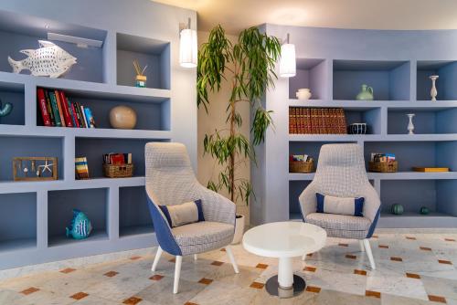 two chairs and a table in a room at Hotel Plaza in Porto Azzurro