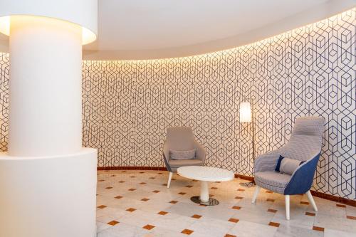two chairs and a table in a room at Hotel Plaza in Porto Azzurro