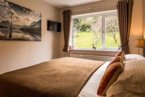 a bedroom with a large bed and a window at Hermiston Guest House in Keswick