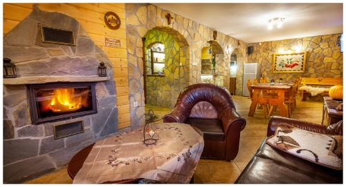 a living room with a stone fireplace and a table at Tatrzańska Kotwica in Witów