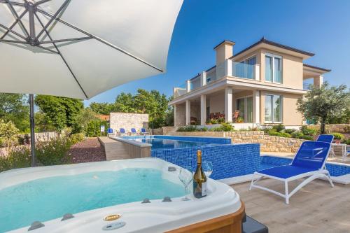 a house with a swimming pool and a hot tub at Villa Roko in Malinska