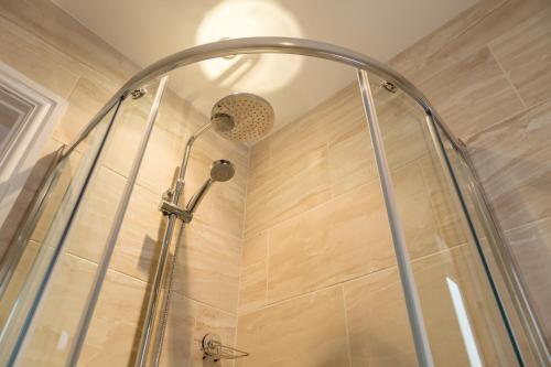 a shower with a shower head in a bathroom at Hermiston Guest House in Keswick