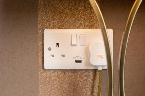 a white electrical outlet on a wall at Hermiston Guest House in Keswick