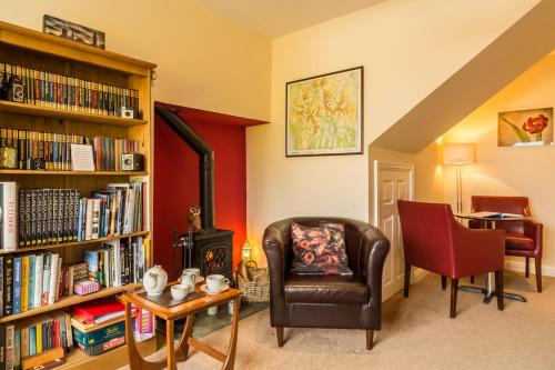 a living room with a chair and a book shelf with books at Hermiston Guest House in Keswick
