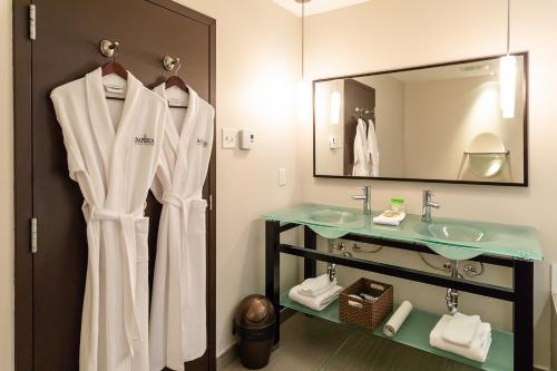 a bathroom with a sink and a mirror at Imperia Hotel & Suites Saint-Eustache in Saint-Eustache