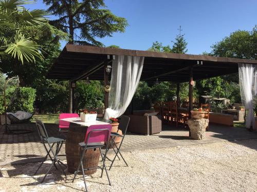 un patio con mesa y sillas bajo un pabellón en B&B Dell'Annunziata en Bevagna