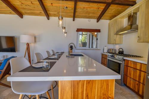 a kitchen with a white counter top and wooden cabinets at Villa Topaz Above West Bay with 360 Degree Views! in West Bay