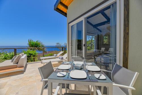 a dining table and chairs with a view of the ocean at Villa Topaz Above West Bay with 360 Degree Views! in West Bay