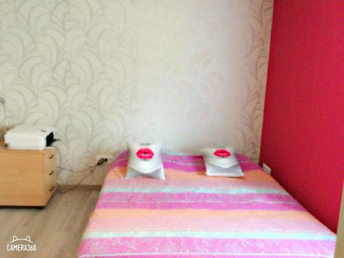 ein kleines Schlafzimmer mit einem Bett mit roten Augen darauf in der Unterkunft Chambre au calme in Saverne