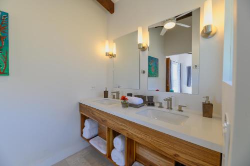 a bathroom with a sink and a mirror at Villa Topaz Above West Bay with 360 Degree Views! in West Bay