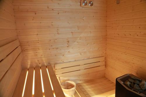 a wooden sauna with a trash can in it at Blue Door Apartment in Augustów