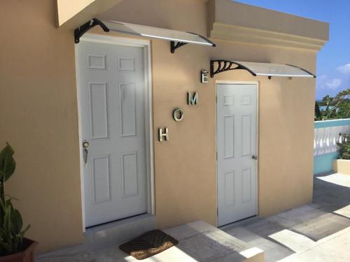 a pair of white doors next to a house at Cool Breeze Discovery Bay in Discovery Bay