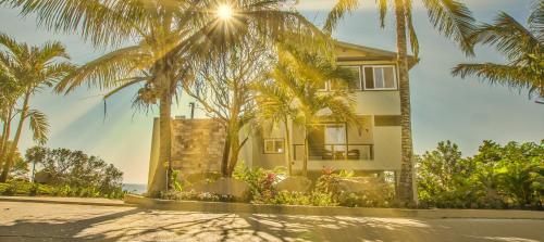 a house with palm trees in front of the ocean at Villa Topaz Above West Bay With 360 Degree Views! 3 Bedrooms in West Bay