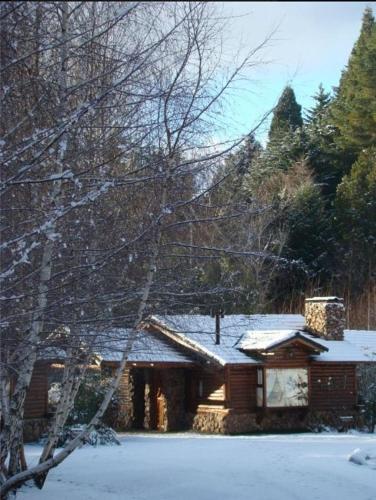 a house with snow on top of it at Cabañas En el Corazón del Bosque in San Carlos de Bariloche