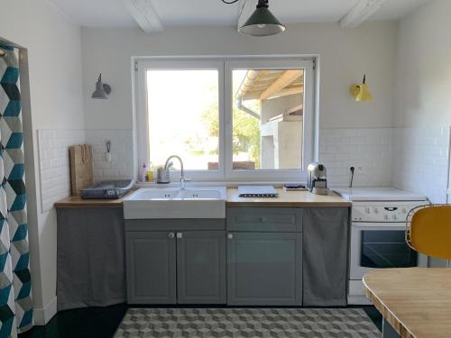 une cuisine avec un évier et une fenêtre dans l'établissement L'Atelier des dépendances, à Lipsheim