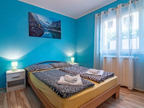 a blue bedroom with a bed with towels on it at Apartman Arijana 3 in Medulin