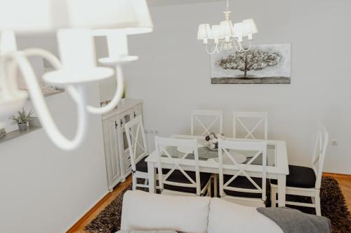 un soggiorno con tavolo e sedie bianchi di Apartman M5 a Ðakovo