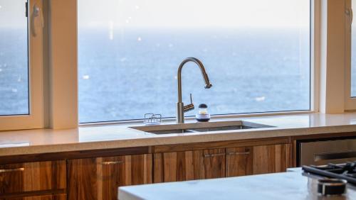 a kitchen with a sink and a large window at Villa Topaz Above West Bay With 360 Degree Views! 3 Bedrooms in West Bay