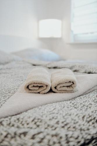 a pair of towels sitting on top of a bed at Apartman M5 in Đakovo