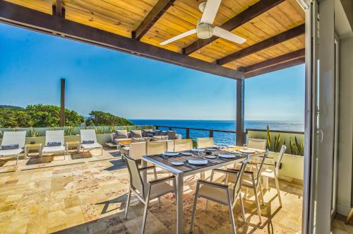 a dining room with a view of the ocean at Villa Topaz Above West Bay With 360 Degree Views! 3 Bedrooms in West Bay