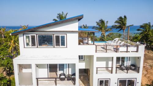 a white house with a view of the ocean at Villa Topaz Above West Bay With 360 Degree Views! 3 Bedrooms in West Bay