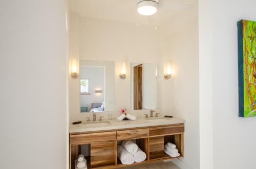 a bathroom with a sink and a mirror at Villa Topaz Above West Bay With 360 Degree Views! 3 Bedrooms in West Bay