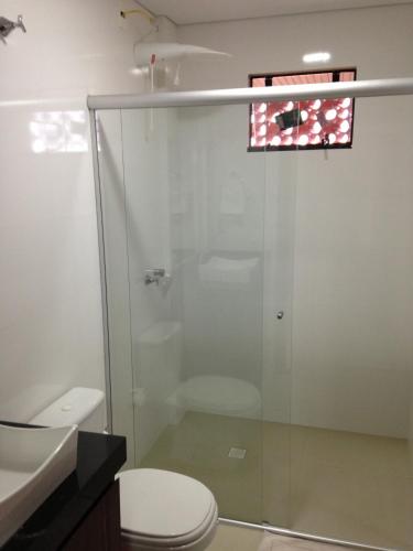a bathroom with a shower and a toilet at Hotel Itatiaia in Tangara da Serra